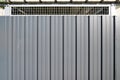 Steel vertical striated metal wall with mesh on the upper part background grey board panel Royalty Free Stock Photo