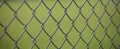 Steel wire mesh fence with green blurred background. Close up view with details. Royalty Free Stock Photo