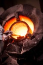 Steel worker in protective clothing raking furnace in an industrial foundry Royalty Free Stock Photo