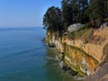 Steep cliff at the Pacific Ocean with house perilously close to the abyss