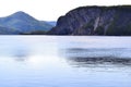 Steep cliffs casting bright reflections across Bonne Bay