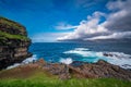 Steep coastline with tourists in Faroe Islands
