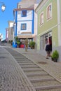 Steep cobbled street Porto Fundo with colorful buildings and a bronze statue representing a man standing