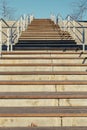 Steep flights of stairs with metal railings and blue sky at the top Royalty Free Stock Photo