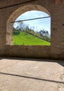 Steep green field view through a stone porch