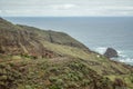 Steep high lava rock cliffs on on the east of Tenerife. Solitary rocks sticking out of the water. Old abandoned huts. Blue sea