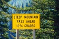 Steep mountain pass traffic warning sign advising motorists of a steep ten percent mountain grade that requires the driver to pay Royalty Free Stock Photo