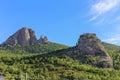 The steep mountain was treeless and surrounded by thick, deep forest