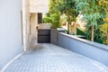 Steep paving descent to the parking lot. Automatic shutter Rolling gates. Residential complex with lots of greenery. Royalty Free Stock Photo