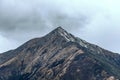 Steep rocky peak under a cloudy sky in Tibet