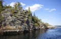 Steep rocky shore of granite island in sunlight,