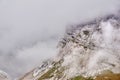 Steep rocky slope partially obscured by a cloud Royalty Free Stock Photo