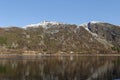 The steep sides of a Norwegian Fjord at Dawn with the morning Sun catching the snow capped mountains Royalty Free Stock Photo