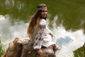 Steep slender Ukrainian woman resting sitting on a stump on the