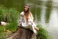 Steep slender Ukrainian woman resting sitting on a stump on the