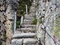 Steep stairway carved out of stone on a mountain path. Steel cables on its sides. Orobie. Italian Alps Royalty Free Stock Photo