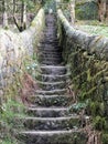 Steep stone stairs with walls joining countryside pathway Royalty Free Stock Photo