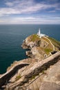 Steep stone steps leading to a white lighthouse on the cliffs a rugged coastline. South Stack Lighthouse