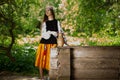 Steep Ukrainian girl with long hair picks up water from a wooden