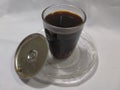 Steeping black coffee served in a clear glass. White background.