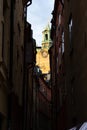 The steeple tower of a church visible high above the other buildings in a narrow alley in old town of Stockholm, Sweden Royalty Free Stock Photo