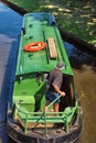 Steering a narrow boat to the bank on the River Wey, Send, Surrey.