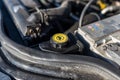 Steering reservoir for power steering fluid inside the engine compartment, visible battery clamp. Royalty Free Stock Photo