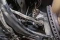 Steering stabilizer connected with steering knuckle, seen from the bottom of the car on a jack in the workshop.