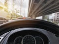 Steering Wheel Against Blurred Speedometer and Traffic Background