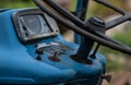 Steering wheel and dashboard of an old, blue Ford tractor..