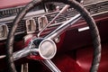 Steering wheel, dials and knobs on dashboard and front panel made of ruby red leather of luxury oldtimer car Royalty Free Stock Photo