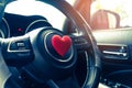 Steering wheel with heart red object.Love car concept idea.interior console car. Royalty Free Stock Photo