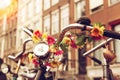 A steering wheel of old bicycle decorated with artificial flowers. Street of Amsterdam.