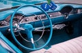 Steering wheel, speedometer, clock, radio scale, buttons and knobs on front panel of blue convertible coupe old timer car Royalty Free Stock Photo