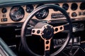 Steering wheel, speedometer, revs, clock dials, radio scale, buttons and knobs on dashboard and front panel of old timer coupe Royalty Free Stock Photo