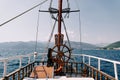 Steering wheel of a wooden schooner near a mast with a mars platform floating on the sea Royalty Free Stock Photo