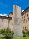 The Holocaust memorial with written stele and green grass and roses