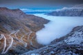 Stelvio pass, mountain road dramatic landscape at dawn above mist, Italy