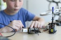 STEM Education, clever kid assemble and learn to program his robot for school project. Smart boy preteen fixing drone