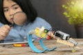 STEM Education concept.A student holding a magnifying glass watching the robot. Royalty Free Stock Photo