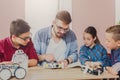 Stem education. Kids creating robots with teacher Royalty Free Stock Photo