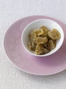 Stem ginger in white bowl pink plate. Conceptual image