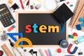 STEM word on blackboard with education equipment for background.