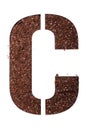 Stencil letter C made above dirt on white surface