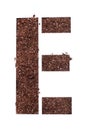 Stencil letter E made above dirt on white surface