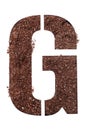 Stencil letter G made above dirt on white surface