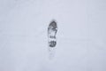 A step against snow background. footprint on white snow background of boots. Human trace on snow