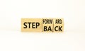 Step back or forward symbol. Concept words Step back Step Forward on wooden cubes. Beautiful white table white background.