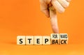 Step back or forward symbol. Concept words Step back Step Forward on wooden cubes. Beautiful orange table orange background.