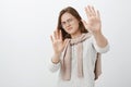 Step back you bother me. Displeased intense cute woman in glasses with short brown hair bending backwards raising palms